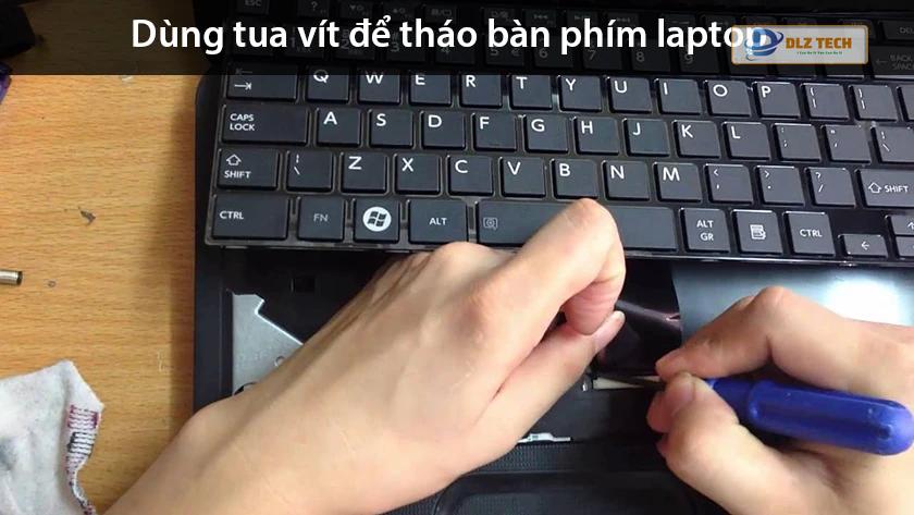 Dùng tua vít tháo ốc bàn phím laptop hp